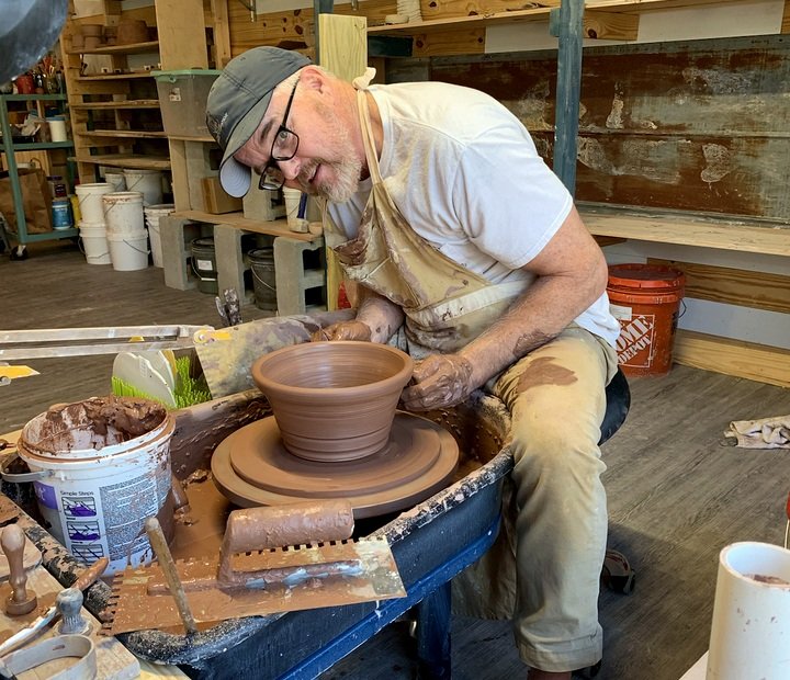 One of our two makers shaping pottery at the wheel