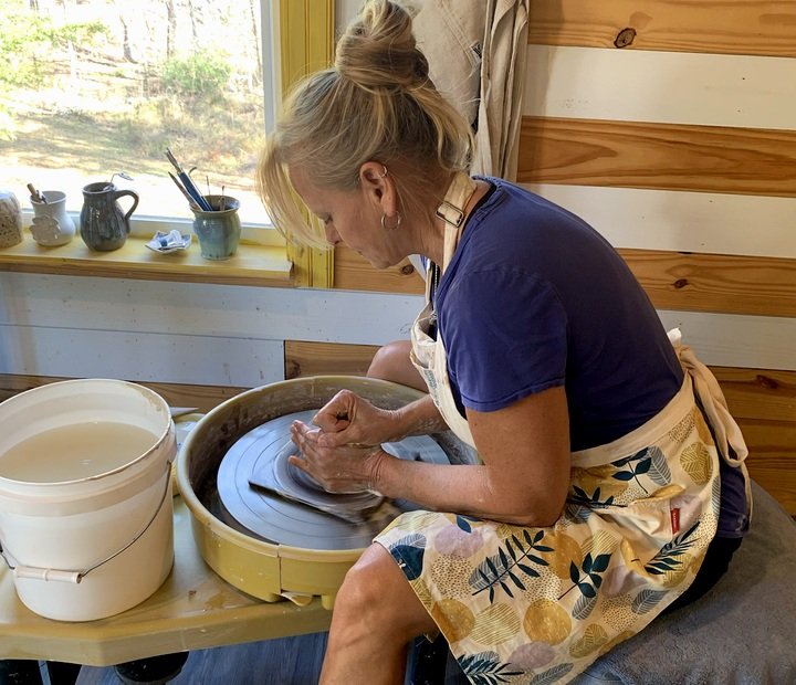 Our other maker shaping pottery in the studio